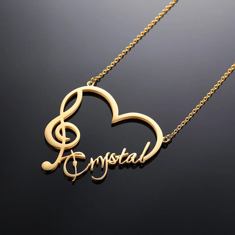 Gold heart-shaped personalized necklace in stainless steel featuring a treble clef and name Crystal.