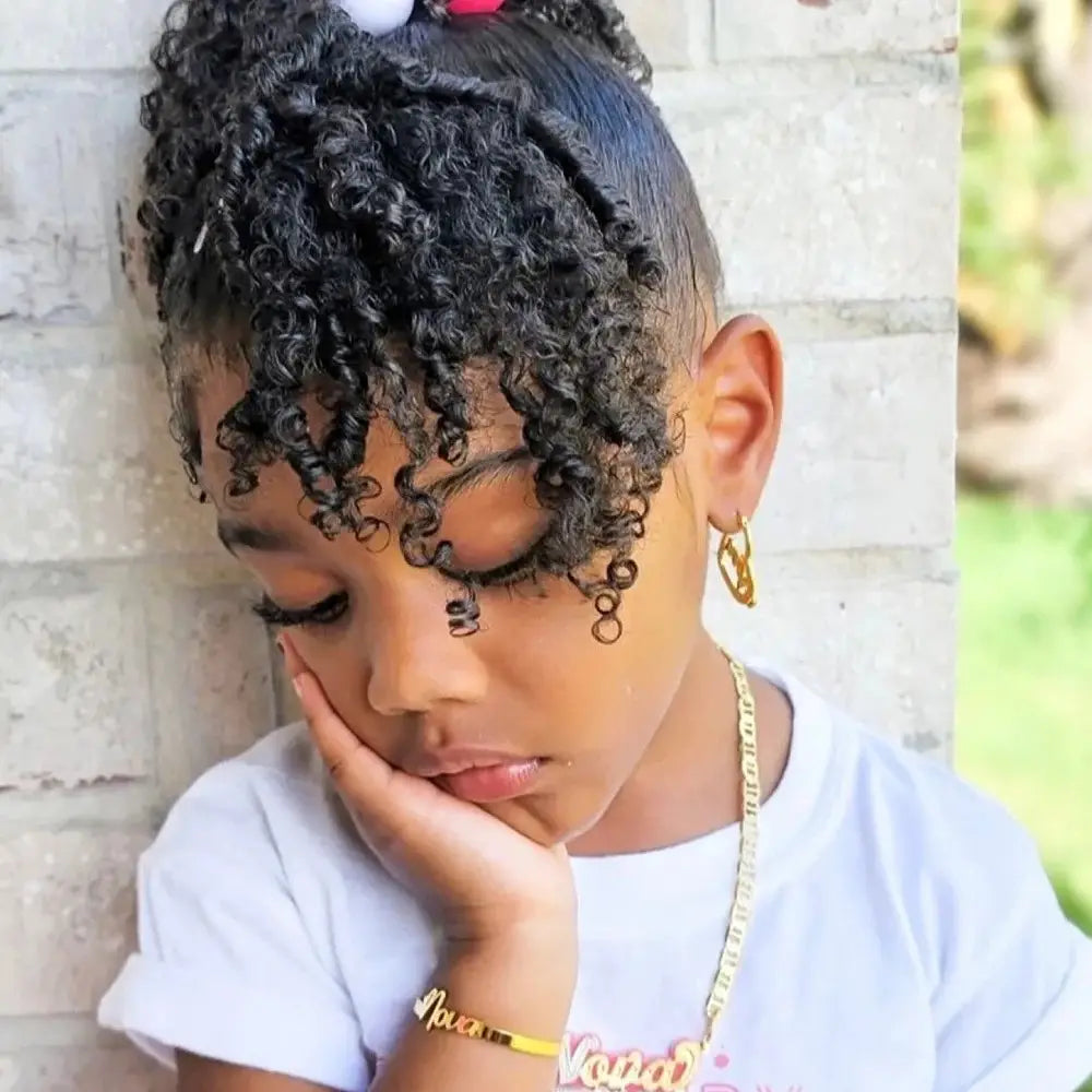 Pensive young girl with curly hair wearing a personalised stainless steel alphabet bracelet