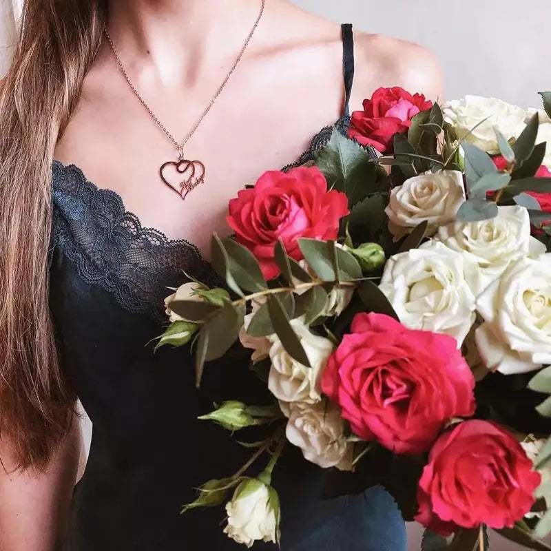 Woman holding roses, wearing a gold Custom Name Double Heart Necklace and stylish jewelry.