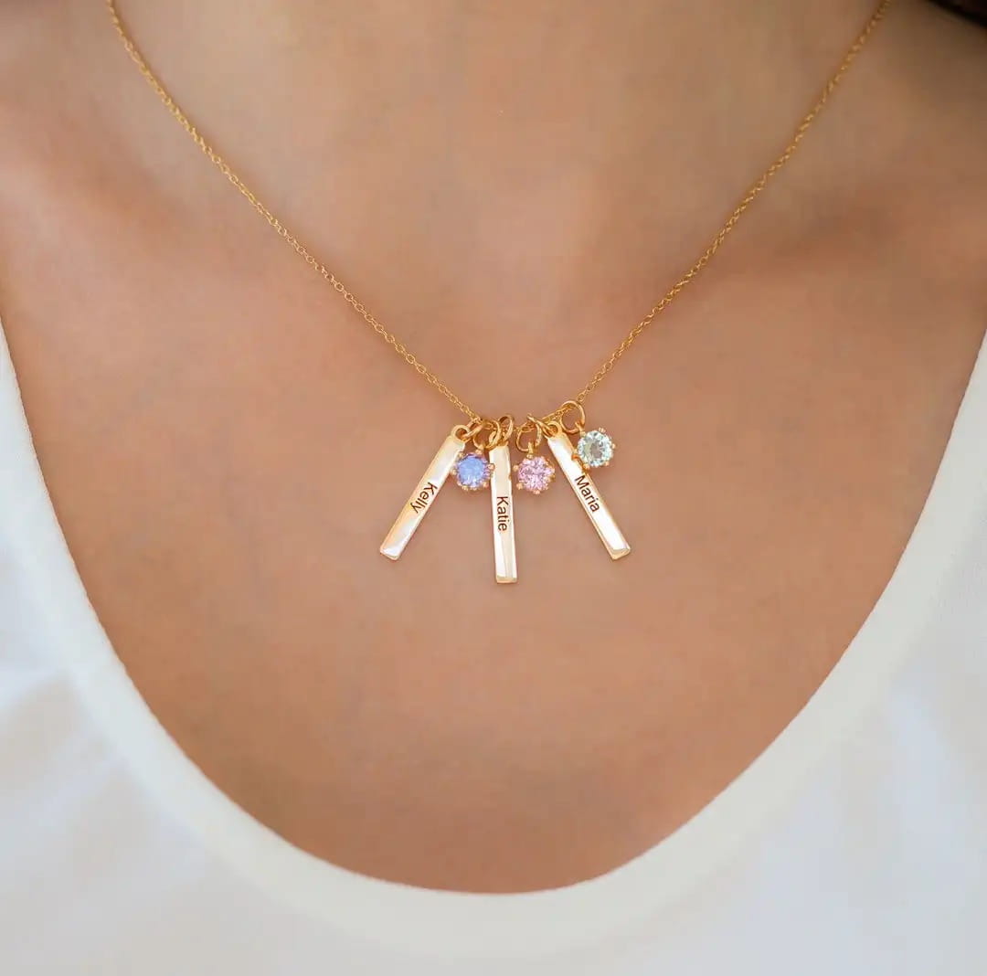 Gold necklace with personalized name pendants and birthstones in stylish stainless steel jewelry.