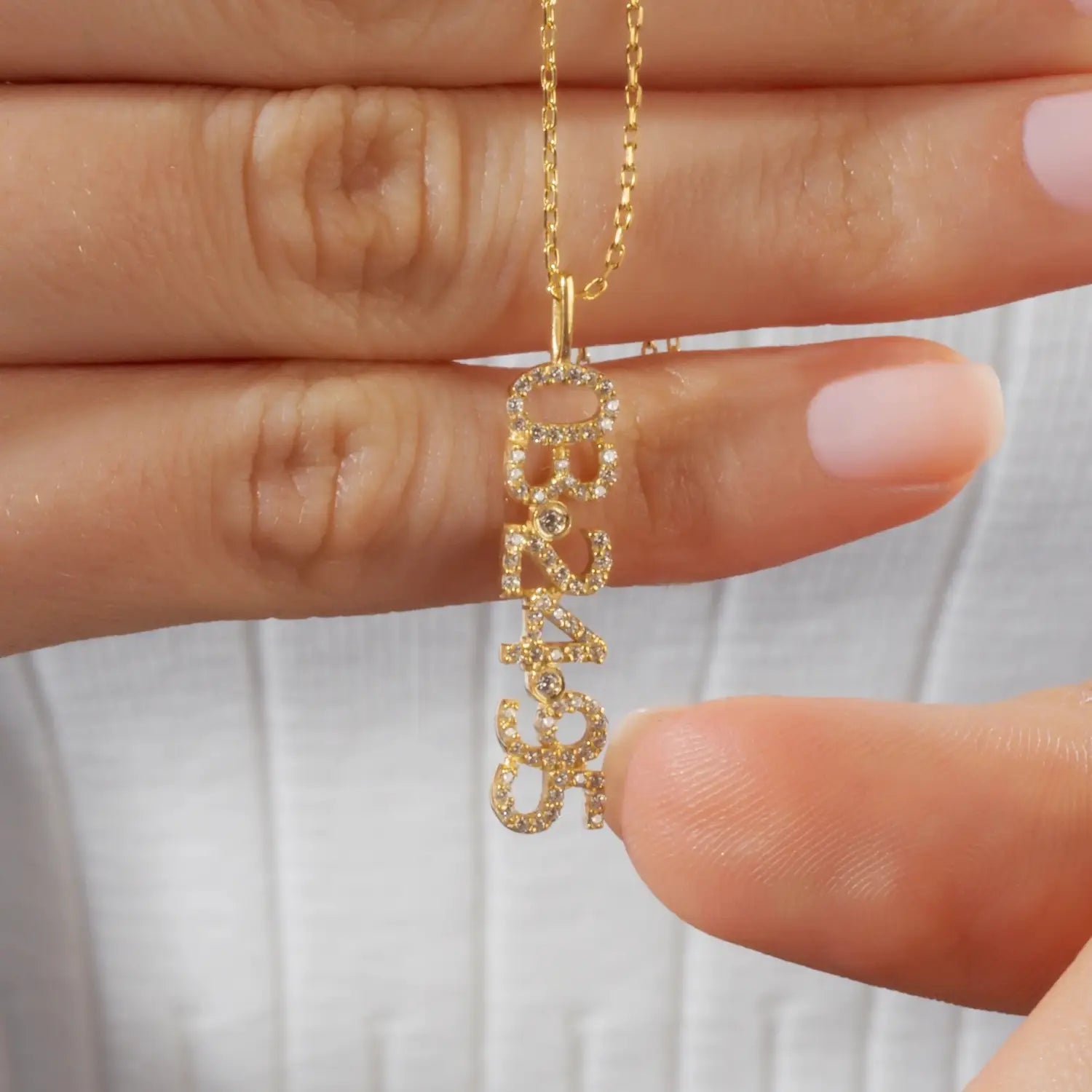 Gold necklace with diamond-studded name pendant for DIY personalized digital bracelet.