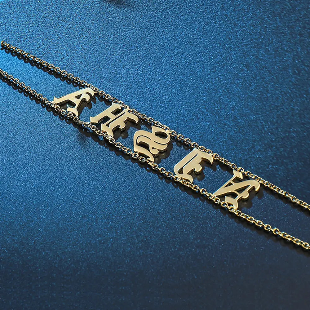 Goldfarbene Namenskette aus Titanstahl mit alten englischen Buchstaben für Schmuckliebhaber