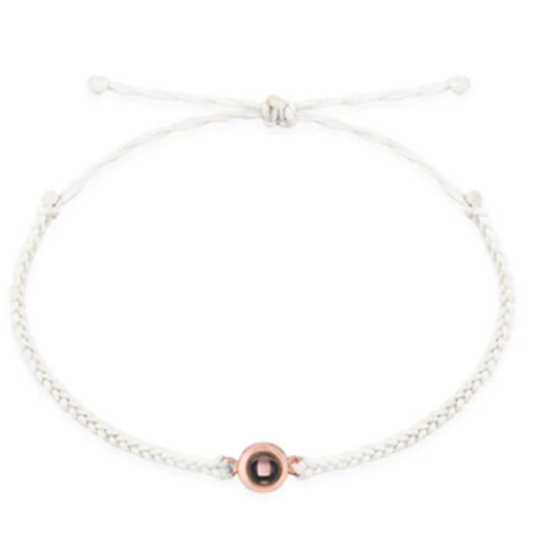Geflochtenes weißes Armband mit roségoldener Perle, perfekt für personalisierte Fotoprojektionen.